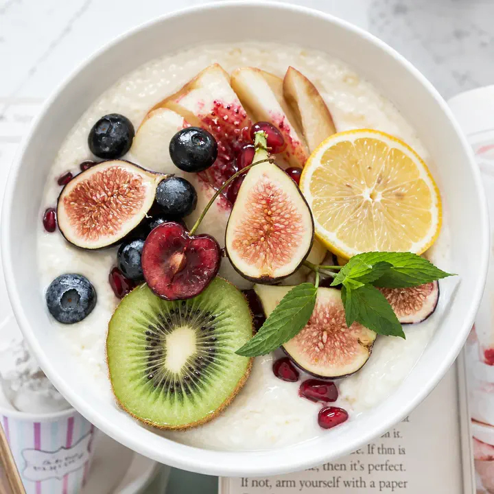 Bol de yaourt garni de figues, kiwi, myrtilles, cerises et agrumes